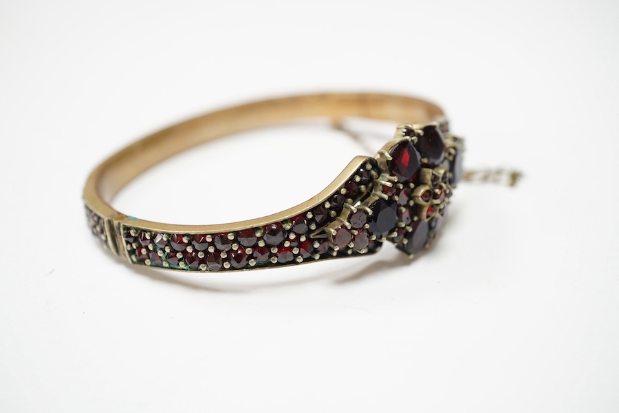 Three items of gilt white metal and garnet paste cluster set jewellery, comprising a bracelet, bangle and pair of Czechoslovakian earrings. Condition - fair